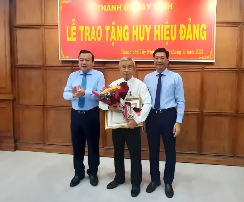 Đồng chí Phạm Hùng Thái (bìa trái)- Phó Bí thư Thường trực Tỉnh ủy Tây Ninh, đồng chí Nguyễn Mạnh Hùng (bìa phải)-Phó bí thư Tỉnh ủy trao huy hiệu và tặng hoa chúc mừng đảng viên