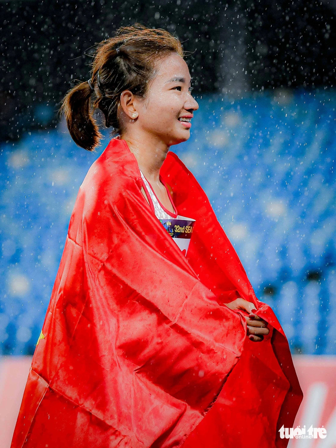Nguyễn Thị Oanh, vận động viên điền kinh của Việt Nam, trở thành biểu tượng của điền kinh Đông Nam Á khi tạo nhiều bất ngờ "không tưởng" tại SEA Games 32. Cụ thể, ngày 9-5, Nguyễn Thị Oanh giành hai huy chương vàng ở hai nội dung khốc liệt là 1.500m, 3.000m vượt chướng ngại vật chỉ trong hơn 30 phút. Oanh cũng giành 4 tấm HCV ở các nội dung khác. Trong ảnh: Nguyễn Thị Oanh trên bục nhận huy chương vàng dưới cơn mưa - Ảnh: NAM TRẦN