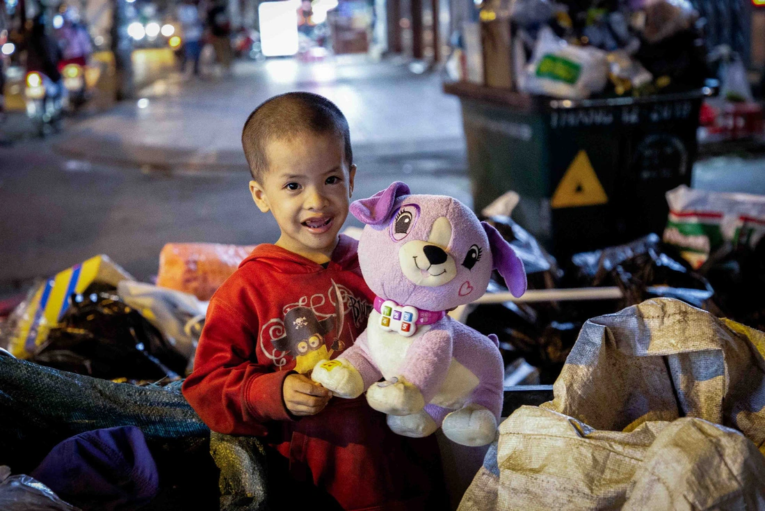Nụ cười của bé Hoàng Khang khi cầm trên tay một con thú nhồi bông. Đây là món quà Khang nhận được từ một nhóm bạn trẻ làm thiện nguyện ở TP.HCM vào đêm 14-1. Hằng đêm, Khang vẫn phải rong ruổi cùng mẹ khắp các tuyến đường, ngõ hẻm nhặt ve chai, phân loại rác để kiếm thêm thu nhập - Ảnh: PHƯƠNG QUYÊN